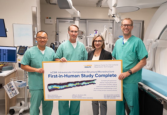 The NCIBT team with the cath lab members are celebrating the completion of the study. Two individuals are holding a banner in the center.